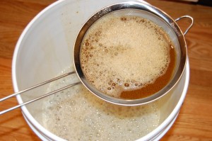 Pour the wort through the strainer into the bucket